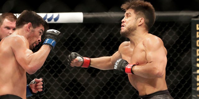 Henry Cejudo, right, punches Dominick Cruz during a UFC 249 mixed martial arts bout, Saturday, May 9, 2020, in Jacksonville, Fla. (Associated Press)