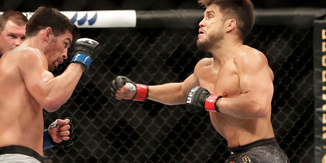 Henry Cejudo, right, punches Dominick Cruz during a UFC 249 mixed martial arts bout, Saturday, May 9, 2020, in Jacksonville, Fla. (Associated Press)