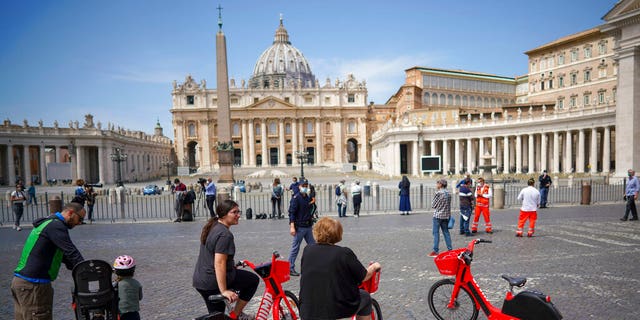 Faithful gather outside the square as Pope Francis delivers his blessing from the window of his studio overlooking St. Peter's Square, due to anti-coronavirus lockdown measures, at the Vatican, Sunday, May 10, 2020. 