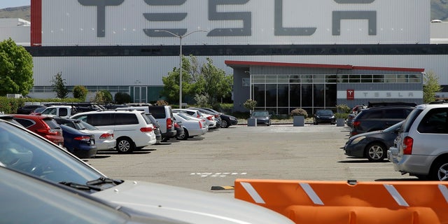 Vehicles are seen parked at the Tesla plant Monday in Fremont, Calif. The parking lot was nearly full at Tesla's California electric car factory Monday, an indication that the company could be resuming production in defiance of an order from county health authorities. (AP Photo/Ben Margot)