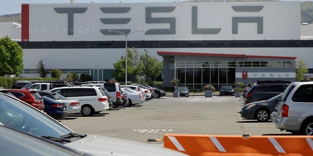 Vehicles are seen parked at the Tesla plant Monday in Fremont, Calif. The parking lot was nearly full at Tesla's California electric car factory Monday, an indication that the company could be resuming production in defiance of an order from county health authorities. (AP Photo/Ben Margot)