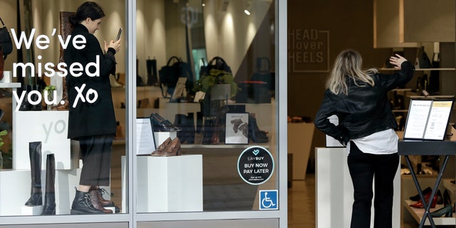 A customer gestures as she walks into a store in Christchurch, New Zealand, May 14. New Zealand lifted most of its remaining lockdown restrictions from midnight Wednesday as the country prepares for a new normal. Malls, retail stores and restaurants will reopen and many people will return to their workplaces. (AP Photo/Mark Baker)