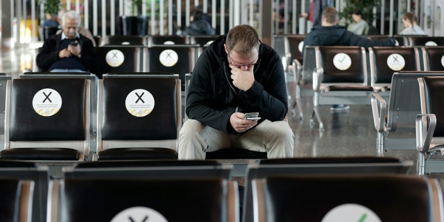 Passengers wait to board their flight at Christchurch Airport in Christchurch, New Zealand, Thursday, May 14, 2020. New Zealand lifted most of its remaining lockdown restrictions from midnight Wednesday (noon Wed GMT) as the country prepares for a new normal. Malls, retail stores and restaurants will reopen and many people will return to their workplaces. (AP Photo/Mark Baker)
