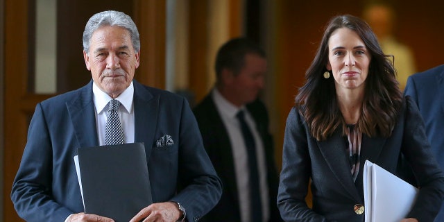 New Zealand Prime Minister Jacinda Ardern walks with Deputy Prime Minister Winston Peters to the house for the budget delivery speech at Parliament in Wellington, New Zealand, Thursday, May 14, 2020. New Zealandユs government plans to borrow and spend vast amounts of money as it tries to keep unemployment below 10 percent in the wake of the coronavirus pandemic. (Hagen Hopkins Pool Photo via AP)