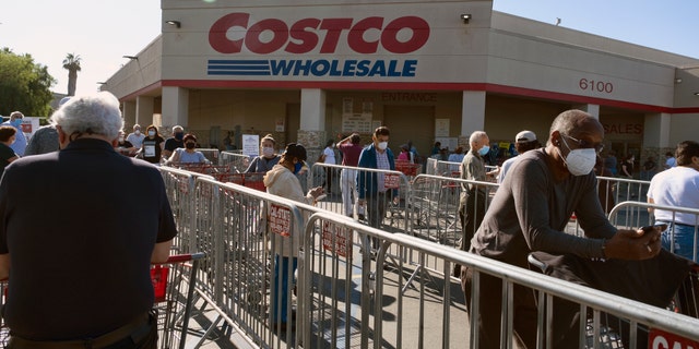 Customers wearing protective masks from the coronavirus and keeping social distancing space line up to enter a Costco Wholesale store in the Van Nuys section of Los Angeles on Saturday. (AP Photo/Richard Vogel)