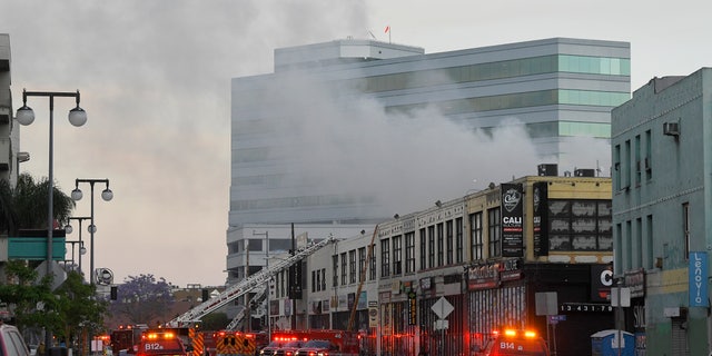 Los Angeles Fire Department firefighters work the scene of a structure fire that injured multiple firefighters, according to a fire department spokesman, Saturday, May 16, 2020, in Los Angeles. (Associated Press)