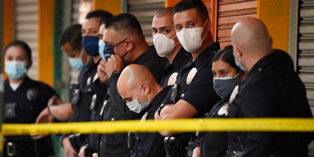 Los Angeles Police Department officers stand at the scene of a structure fire that injured multiple firefighters, according to a fire department spokesman, Saturday, May 16, 2020, in Los Angeles. (Associated Press)