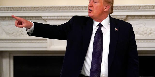 President Donald Trump gestures as he leaves after a meeting with restaurant industry executives about the coronavirus response, in the State Dining Room of the White House, Monday, May 18, 2020, in Washington. (AP Photo/Evan Vucci)