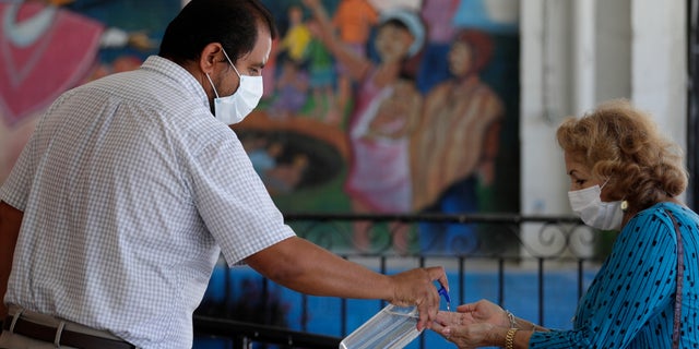 Parishioners wearing face masks are given hand sanitizer as they arrive for an in-person Mass using social distancing at Christ the King Catholic Church in San Antonio, May 19. San Antonio parishes that have been closed due to the COVID-19 pandemic have began opening their doors to in-person services. (AP Photo/Eric Gay)