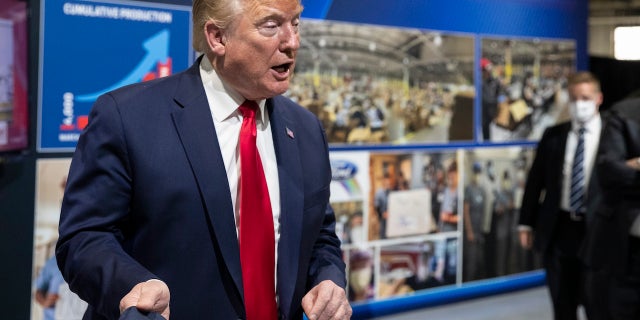 President Trump holds his protective face mask as he speaks while touring Ford's Rawsonville Components Plant that has been converted to making personal protection and medical equipment, Thursday, May 21, 2020, in Ypsilanti, Mich. (Associated Press)