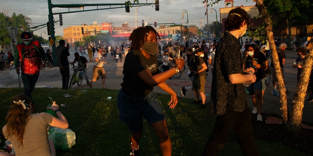 A protester runs away from where police deployed chemical irritants near the 3rd Precinct building in Minneapolis on May 27, during a protest against the death of George Floyd in Minneapolis police custody earlier in the week. (Christine T. Nguyen/Minnesota Public Radio via AP)