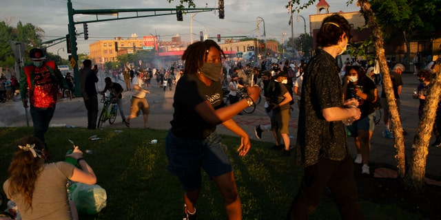 A protester runs away from where police deployed chemical irritants near the 3rd Precinct building in Minneapolis on May 27, during a protest against the death of George Floyd in Minneapolis police custody earlier in the week. (Christine T. Nguyen/Minnesota Public Radio via AP)