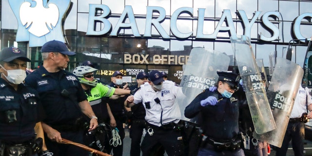 Police officers protect themselves with shields as protesters throw debris during a rally at the Barclays Center over the death of George Floyd, a black man who was in police custody in Minneapolis Friday, May 29, 2020, in the Brooklyn borough of New York. Floyd died after being restrained by Minneapolis police officers on Memorial Day. (AP Photo/Frank Franklin II)