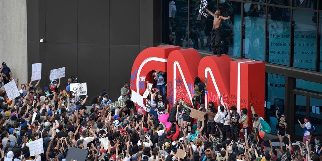 Demonstrators paint on the CNN logo during a protest, Friday, May 29, 2020, in Atlanta, in response to the death of George Floyd in police custody on Memorial Day in Minneapolis. (Associated Press)