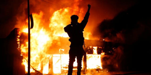 In this May 29, 2020, photo, a check-cashing business burns during protests in Minneapolis. Protests continued following the death of George Floyd, who died after being restrained by Minneapolis police officers on Memorial Day. (AP Photo/John Minchillo)