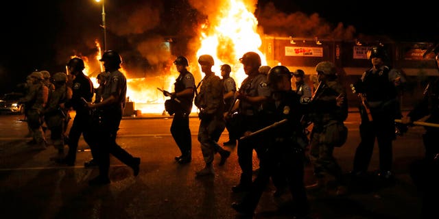 Police clear the street for firefighters during protests Friday, May 29, 2020, in Minneapolis. Protests continued following the death of George Floyd, who died after being restrained by Minneapolis police officers on Memorial Day. 