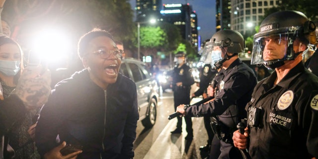 A protester yells at police during a protest for George Floyd, in downtown Los Angeles, Friday, May 29, 2020. (AP Photo/Ringo H.W. Chiu)