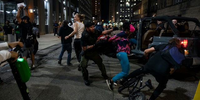 Detroit police officer grabs a protester during a rally calling for an end to police violence and justice for George Floyd Friday May 29, 2020. Nicole Hester/Mlive.com