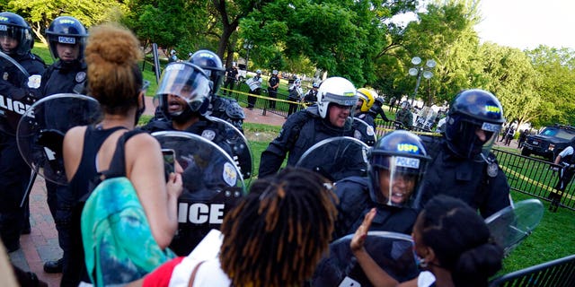 Demonstrators vent to police in riot gear as they protest the death of George Floyd, Saturday, May 30, 2020, near the White House in Washington. Floyd died after being restrained by Minneapolis police officers. (AP Photo/Evan Vucci)