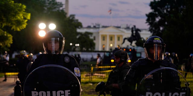 Police in riot gear stand in front of the White House as demonstrators gather to protest the death of George Floyd, Saturday, May 30, 2020, outside the White House in Washington. Floyd died after being restrained by Minneapolis police officers. (AP Photo/Evan Vucci)