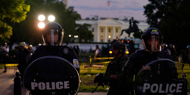 Police in riot gear stand in front of the White House as demonstrators gather to protest the death of George Floyd, Saturday, May 30, 2020, outside the White House in Washington. Floyd died after being restrained by Minneapolis police officers. (AP Photo/Evan Vucci)