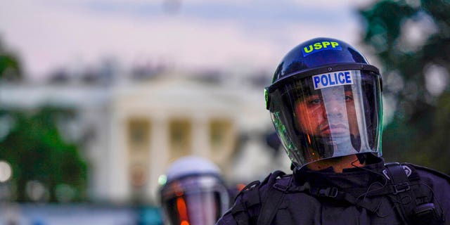 Police in riot gear stand in front of the White House as demonstrators gather to protest the death of George Floyd, Saturday, May 30, 2020, outside the White House in Washington. Floyd died after being restrained by Minneapolis police officers. (AP Photo/Evan Vucci)
