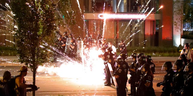 A firework explodes by a police line as demonstrators gather to protest the death of George Floyd, Saturday, May 30, 2020, near the White House in Washington. (AP Photo/Alex Brandon)