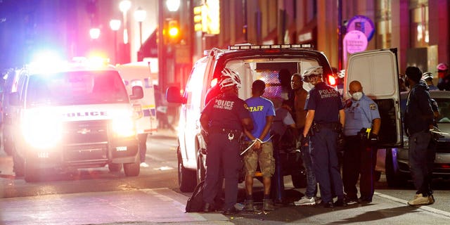 Philadelphia police officers detaining people Saturday as protests devolved into riots.