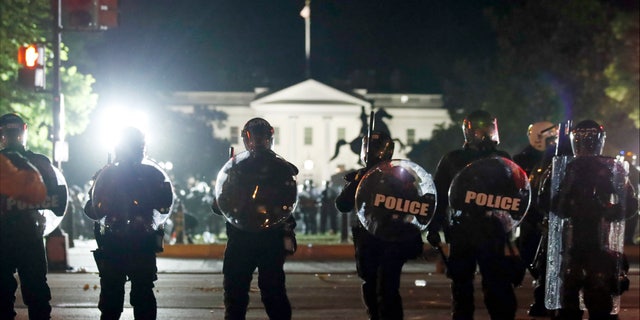 Police form a line on H Street as demonstrators gather to protest the death of George Floyd, Sunday, May 31, 2020, near the White House in Washington. Floyd died after being restrained by Minneapolis police officers (AP Photo/Alex Brandon)