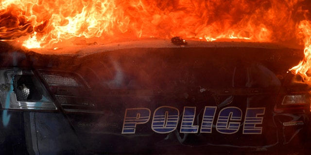 An Atlanta Police Department vehicle burns during a demonstration against police violence, Friday, May 29, 2020 in Atlanta.