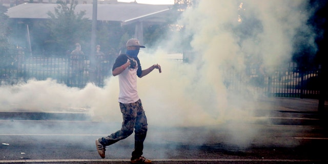 Demonstrators protest in a fog of gas that the Atlanta Police launched at a crowd, Saturday, May 30, 2020 in Atlanta.