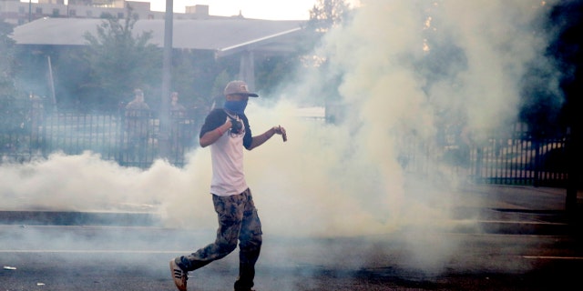 Demonstrators protest in a fog of gas that the Atlanta Police launched at a crowd, Saturday, May 30, 2020 in Atlanta.