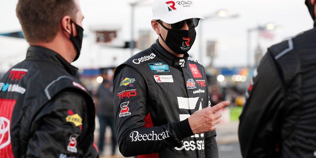 Kyle Busch, center, waits for the start of a NASCAR Truck Series auto race at Charlotte Motor Speedway Tuesday, May 26, 2020 in Concord, N.C. (AP Photo/Gerry Broome)