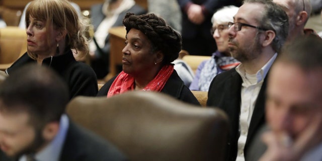 Washington state presidential electors Esther John, center, and Bret Chiafalo, right, sit behind their attorneys Tuesday, Jan. 22, 2019, during a Washington Supreme Court hearing in Olympia, Wash., on a lawsuit addressing the constitutional freedom of electors to vote for any candidate for president, not just the nominee of their party. (AP Photo/Ted S. Warren)