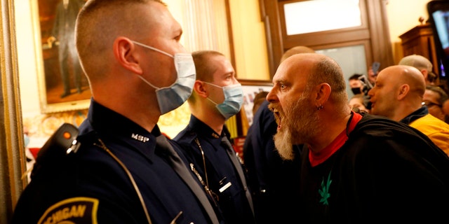 Protestors tried to enter the Michigan House of Representative chamber and were being kept out by the Michigan State Police at the State Capitol in Lansing, on April 30. The group was upset with Michigan Gov. Gretchen Whitmer's mandatory closure to curtail Covid-19. (JEFF KOWALSKY/AFP via Getty Images)