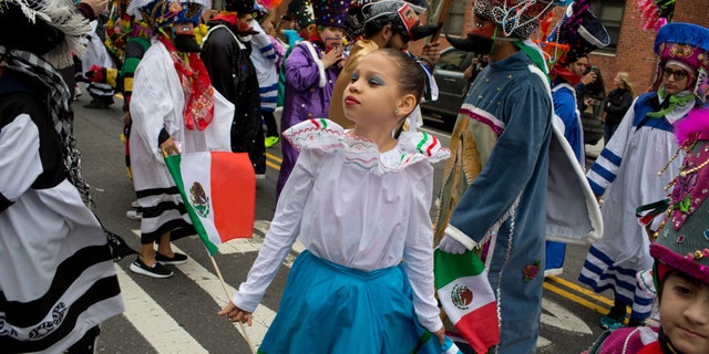  Uma jovem rapariga é vista a participar num desfile do Cinco de Mayo em Nova Iorque em 2018.