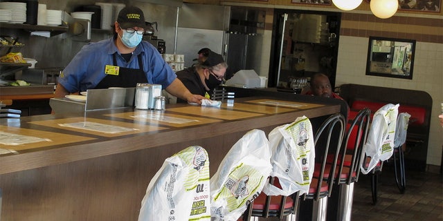 Plastic bags mark off seats to promote social distancing at a Waffle House restaurant in Savannah, Ga., on Monday, April 27, 2020. Restaurants statewide have been allowed to resume dine-in service with restrictions after a month of being limited to takeout meals only because of the coronavirus.