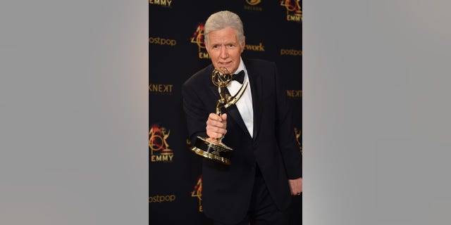 Alex Trebek poses with the Daytime Emmy Award for Outstanding Game Show Host