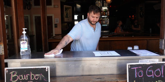 Dane Majoros wipes down the walkup window at the Bourbon Street pub in Key West, Fla. in this March photo. (Joe Raedle/Getty Images)