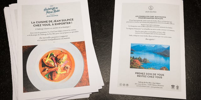 Flyers with special instructions about the take-way meal and advice from Chef Jean Sulpice are displayed in the Auberge du Pere Bise shop on April 19 in Talloires, France. Two Michelin Star chef Chef Jean Sulpice and his team are producing take-away meals for clients due to restaurant closures during France's lockdown.