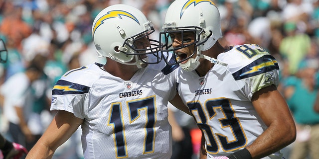 El mariscal de campo Philip Rivers #17 y el receptor abierto Vincent Jackson #83 de los San Diego Chargers celebran después de completar un pase de touchdown de 55 yardas en el primer cuarto contra los Miami Dolphins en el Qualcomm Stadium el 25 de septiembre de 2011 en San Diego, California.