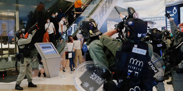Riot police raise their pepper spray projectile inside a shopping mall as they disperse anti-government protesters during a rally, in Hong Kong, China, on Sunday. (Reuters)