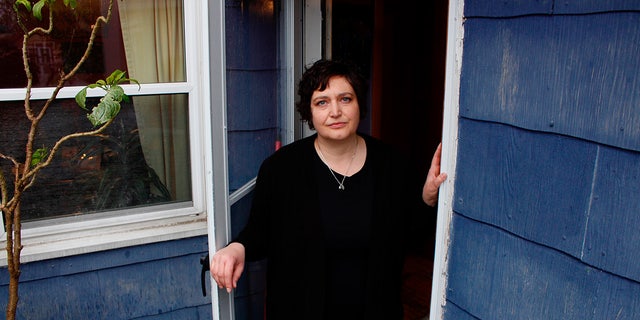 In this April 29 photo, Julie Hitchcock stands in her back doorway in Milwaukee.