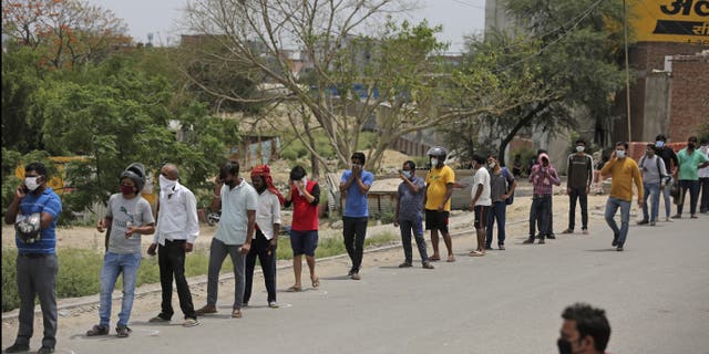 Indians line up to buy liquor outside a shop that reopened Monday after six weeks lockdown on the outskirts of New Delhi. (AP)