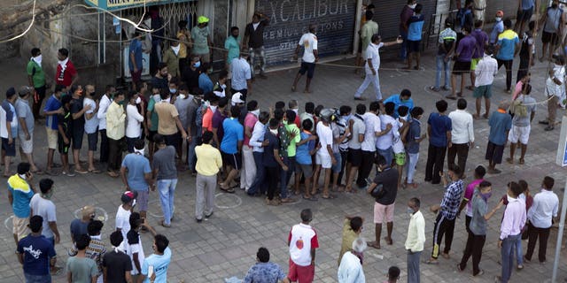 Indians line up without maintaining physical distance to buy liquor on the outskirts of Mumbai on Monday. (AP)