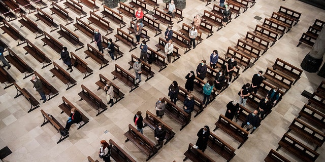 Fiel sentado en los bancos, siguiendo las reglas de distanciamiento social, durante una misa, el primer día que se permitió la presencia de fieles durante las misas, en Turín, Italia, el lunes 18 de mayo de 2020. Italia está levantando lentamente las restricciones sanitarias después de dos meses de bloqueo del coronavirus.  (Marco Alpozzi / LaPresse a través de AP)