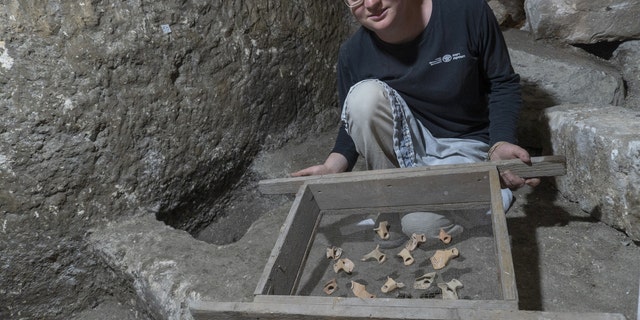 Tehila Sadiel holding the finds. (Shai Halevi-Israel Antiquities Authority)