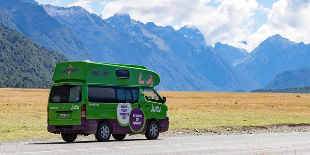 Jucy's famous green van driving through New Zealand.