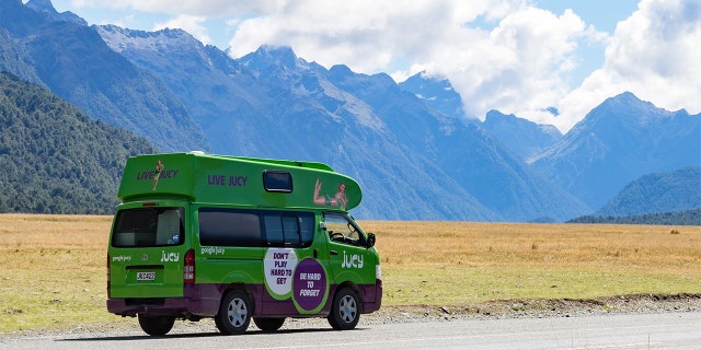 Jucy's famous green van driving through New Zealand.