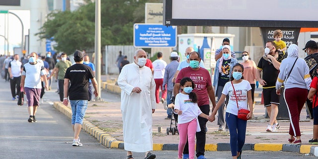 Mask-clad residents walk in a neighborhood of Kuwait City on May 12, as authorities allowed people to exercise for two hours under a nationwide lockdown due to the COVID-19 pandemic. (Photo by YASSER AL-ZAYYAT / AFP)